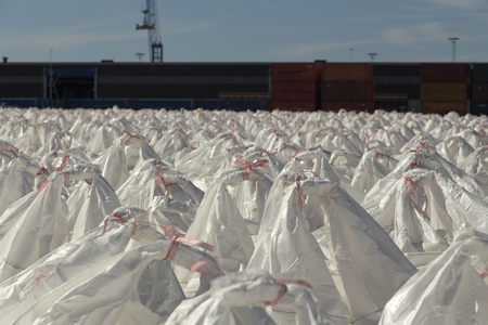 A huge number of bags in front of some containersの写真素材