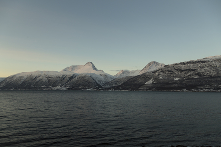The ocean and snow covered mountains in the background