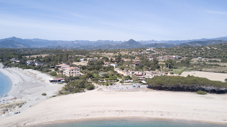 Shore line and a small village with a beach with sand in the foregroundの写真素材