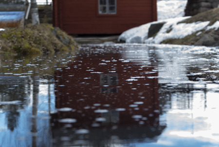 water reflection of a house in a little pond during late winterの写真素材