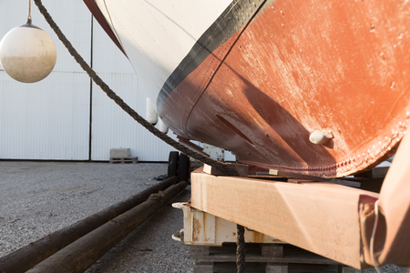 A boat on a trailer on dry land with some haning fendersの写真素材