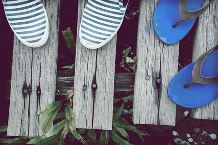 Background sandals and sneakers. The background is a wooden floorの写真素材