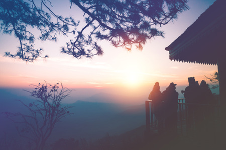 Wallpaper background Tourists photograph the sunrise in the morning on the mountain.. phurue thailand Tropical forestsの写真素材