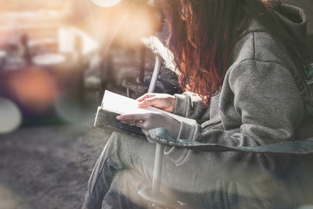 Woman relaxing reading on a chair in a forest park.の写真素材