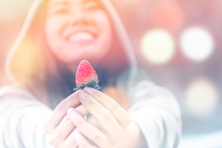 Fresh strawberries closeup. holding strawberry in hands womanの写真素材