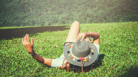 Asian women travel relax in the holiday. Sleep relax on the lawn on the mountain. In Thailand