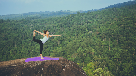 Asian women relax in the holiday. Play if yoga. On the Moutain rock cliff. Nature of mountain forests in Thailandの写真素材
