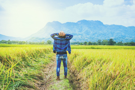 Asian man travel relax in the holiday. Stand natural touch mountain field. Thailandの写真素材