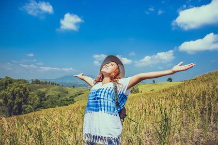 Asian women travel relax in the holiday. Stand natural touch mountain field. Thailandの写真素材