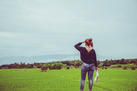 Asian women relax in the holiday. read a book on a green pasture.の写真素材