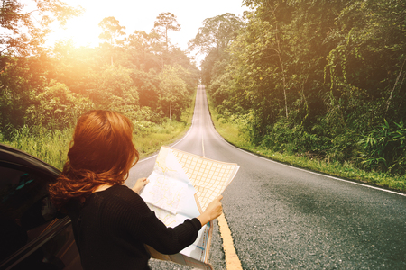 woman  travel. Female travelers travel nature mountain map navigation. Travel by carの写真素材