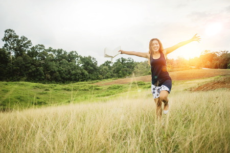 Asian women relax in the holiday. read a book on a green pasture.の写真素材