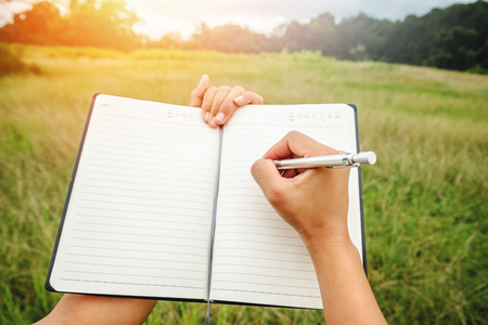 Handwriting on notebook relax in the holiday. on a green pasture.の写真素材