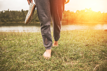 Asian women relax in the holiday. Walking foot on the meadowの写真素材
