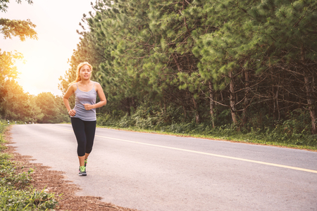 Women exercise running on the street. Nature park. Asian womenの写真素材