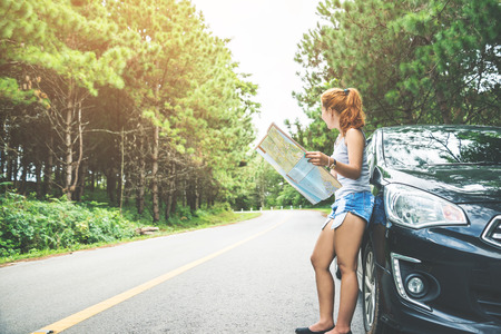 woman  travel. Female travelers travel nature mountain map navigation. Travel by carの写真素材