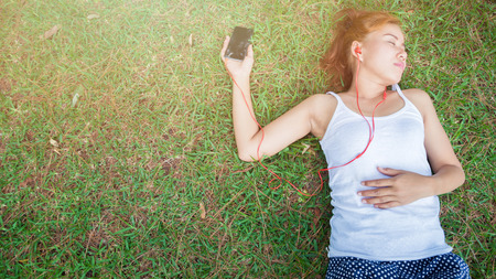 Women listen to music Relax in the nature park.