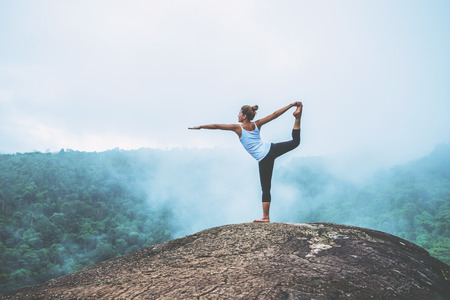 Asian women relax in the holiday. Play if yoga. On the Moutain rock cliff. Nature of mountain forests in Thailandの写真素材