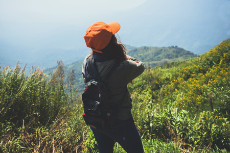 Asian women travel relax in the holiday.  Stand and watch landscape on the Moutain. Mountain Park happily. In Thailandの写真素材