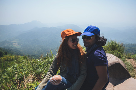 Lover women and men asians travel relax in the holiday. Sit and watch landscape on the Moutain....