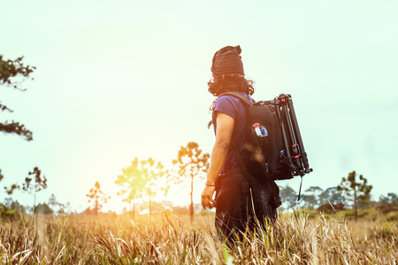 Asian men travel  nature. Travel relax.Backpack walk on the meadow in the forest. Thailand