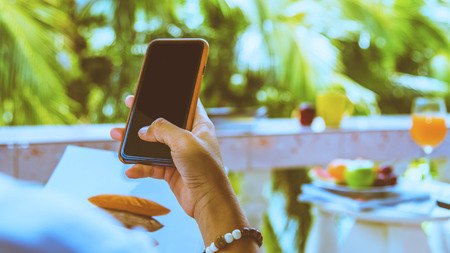 woman holding the mobile phone and relax in the holidayの写真素材