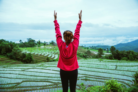 Asian woman relax in the holiday. Play if yoga. On the balcony landscape Natural Field. papongpieng...