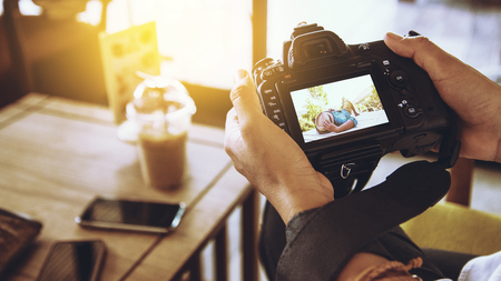 Asian woman sitting relax on the sofa. Viewing photos in camera