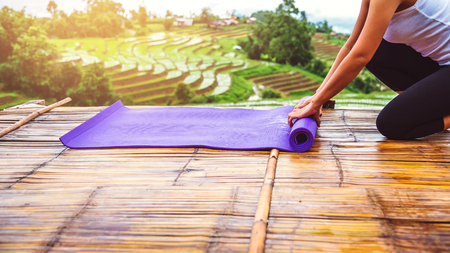Asian woman relax in the holiday. Play if yoga. On the balcony landscape Natural Fieldの写真素材