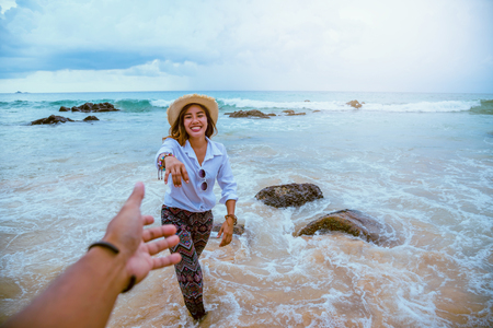 Asian lovers happy travel nature on the beach. Couple running on a sandy beach.Travel relax in summerの写真素材