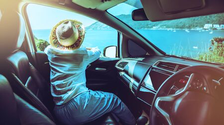 Woman drive a car travel relax to the beach in the summer holiday. Looking out of the car window to...