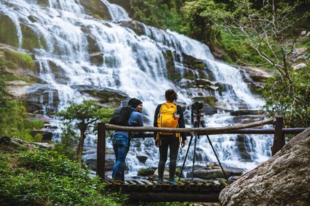couples travel relax to photograph the waterfalls beautiful. In the winter. at the waterfall mae ya...