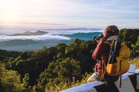 The young woman travels to take pictures of the sea mist on the mountain. Travel relax. Natural...