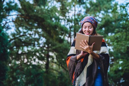 Asian woman travel nature. Travel relax. Study read a book. Nature Education Write a note At public park in summer. In Thailandの写真素材
