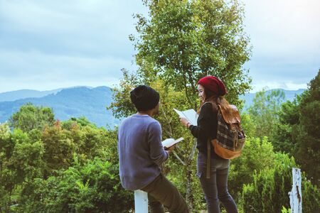 Asian couple travel relax in the holiday. Study read a book. Read a book In the garden on the...