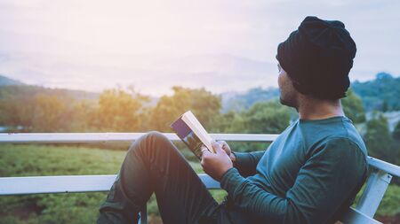 Man traveler is reading book travels nature on the mountain In the fresh air in the north, Chiang Mai in Thailand.の写真素材