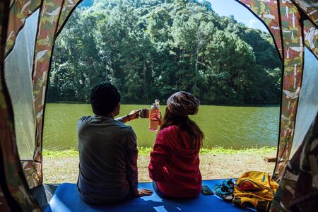 couple travel camping tents in pine tree forest by the lake at Pang Oung Lake Mae hong son, Thailand.の写真素材