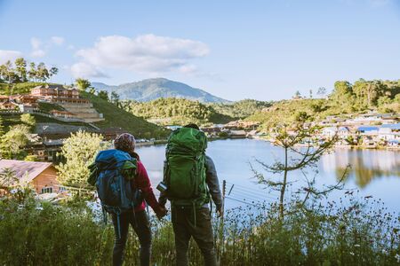 Lover women and men asians travel relax in the holiday. Stand up looking landscape on the mountains. Happy with relaxing tourism.の写真素材