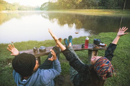 Asian couples feel relaxed and happy with morning drinking coffee by the lake. Couple romantic traveling camping, Honeymoon.の写真素材