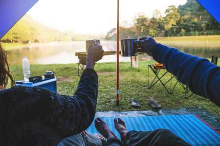 The view inside the couple's tent is sitting in the morning coffee. Couple travel camping tents, Travel nature. Travel relax, Camping lake in Thailand.の写真素材