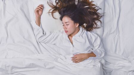 Young Woman Sleeping In Bed. Top view of young woman lying down sleeping well in bed. sleeping...