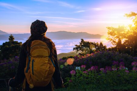 Young woman Tourists with backpacks Standing watching nature beautiful landscape view And fog on the...