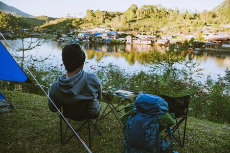 Asian man travel nature. Travel relax, Camping in a rural village on the mountain, near the lake.の写真素材