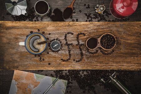 equipment material about coffee beans. Top view with copy space for your text. Coffee message write on a wooden table. Concept travel with map.の写真素材