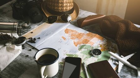 Tourist planning vacation with the help of world map and compass along and Coffee cup with coffee grinder with other travel accessories. Preparing for travel. Travel planning concept holiday with map. summer.の写真素材