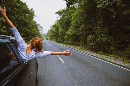 Asian women travel relax in the holiday. Traveling by car park. happily With nature, rural forest. In the summer. Woman driving a car traveling happily.の写真素材