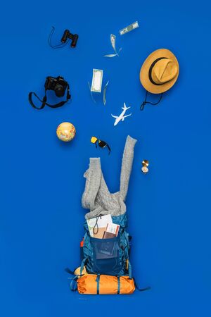 The concept of organizing equipment for traveling Put on the Luggage. concept accessory for travelers Vacation with a map,  passport on Blue color background. Travel backpackの写真素材