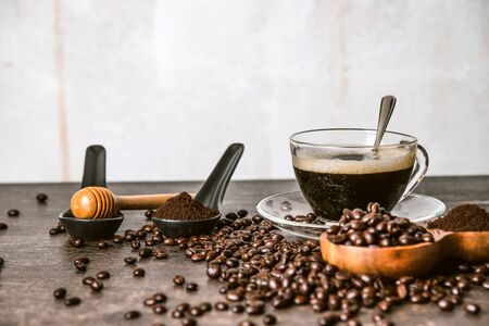 Coffee cup and roasted coffee beans In the bag and honey on a wooden table background