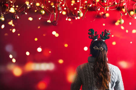Christmas New Year. Young Woman dressed in warm sweater with  Props ball red with christmas...