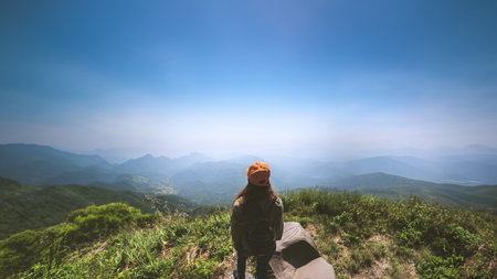 Asian women travel relax in the holiday.  Stand and watch landscape on the Moutain. Mountain Park...
